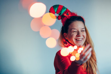 Portrait of a woman wearing Christmas costume and holding lights