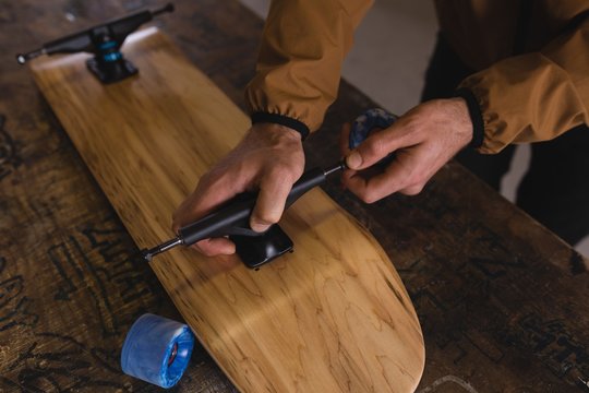 Man repairing skateboard in workshop