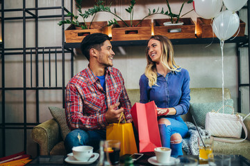 Young couple enjoying in modern cafe after shopping.