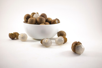 Fresh longan fruits in a white bowl isolated on white background