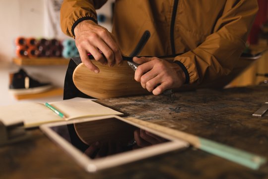Man repairing skateboard in workshop
