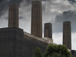 Four Tall Chimneys Against A Stormy Sky