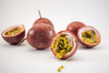 Plenty of passion fruit isolated. Whole passionfruits and a halfs of maracuya isolated on white background