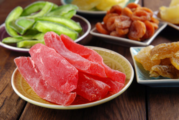 Dried fruits of papaya, mango, pineapple, pomelo, dried apricots on a wooden background.