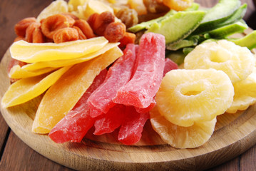Dried fruits of papaya, mango, pineapple, pomelo, dried apricots on a wooden background.