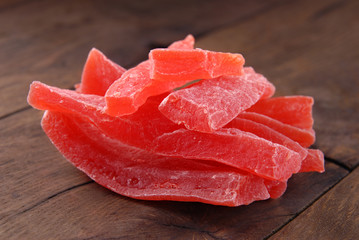 Dry papaya in a plate on a brown wooden background.