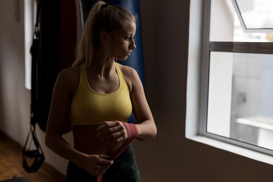 Female boxer wearing hand wrap in fitness studio