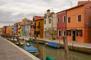 Fototapeta na wymiar Burano Island - part of Venice, colored houses on the background of the channel.