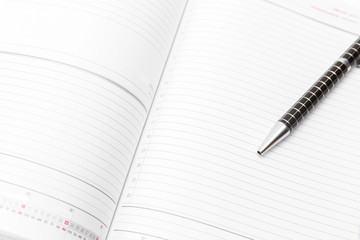 Open notebook with black pen on white background. Isolated on white