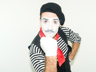 Mime man looking angry at camera and showing his fist up. Anger concept. isolated on white...
