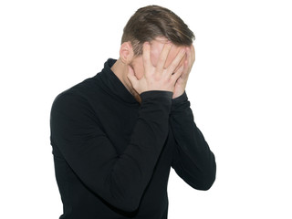 Portrait of  despair young man closed face by two hands. Isolated on a white background.