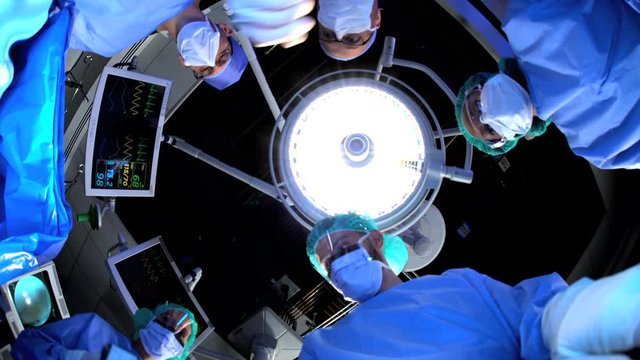 POV Orthopedic surgical operation performed by multi ethnic medical staff on patient at healthcare hospital with surgeons using mechanical instruments