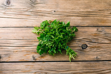 Fresh green parsley on a wooden table in hand
