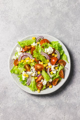 Tomato goat cheese corn salad with spicy dressing. Top view, space for text.