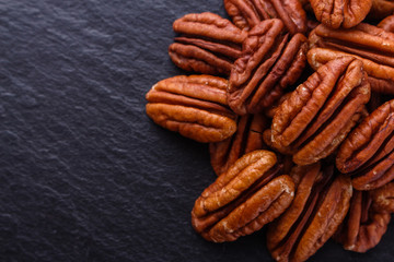 delicious pecan nuts on a dark stone background