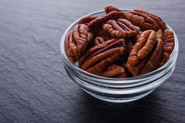 delicious pecan nuts on a dark stone background