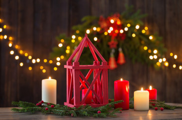 wooden lantern with candles and Christmas branchs on wooden background