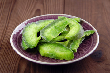 Slices of dry pomelo on a wooden background.