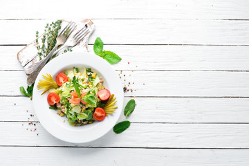 Tuna salad and fresh vegetables on a white wooden background. Free space for your text. Top view.