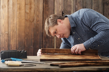 carpenter working with tools on wooden background