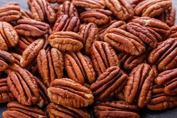 delicious pecan nuts on a dark stone background