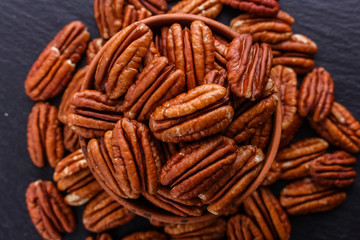 delicious pecan nuts on a dark stone background