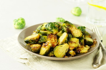 Brussels sprouts roasted fried with onions on a plate top view. Vegetable vegetarian food.