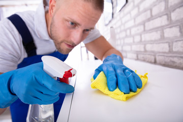 Janitor Cleaning Furniture With Cloth