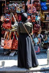 the woman in front of shop window with shopping bags