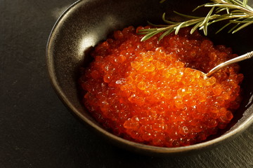 red caviar close-up in a dark bowl