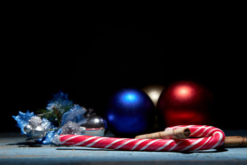 Christmas candy with waffles and decorations on an old weathered tree on a black background