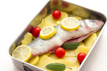 Fish with lemon potatoes and tomatoes ready for the oven