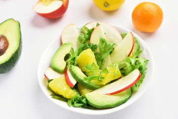 Salad with red apples, avocado, orange slices