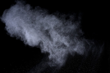 White powder explosion on black background. Colored cloud. Colorful dust explode. Paint Holi.