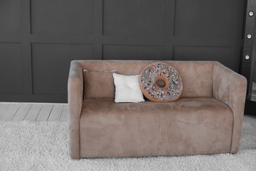 brown sofa. black wall couch. donut pillow