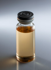 small medicine bottle, with yellow inside, on a white background, close-up, selective focus