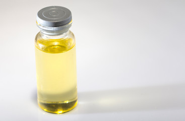 small medicine bottle, with yellow inside, on a white background, close-up, selective focus
