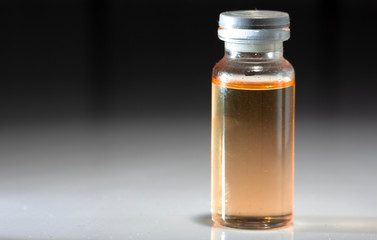 small medical butylochka, with yellow inside, on a black background, close-up,