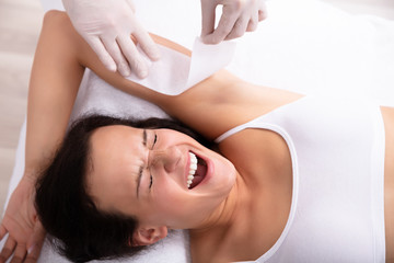 Obraz na płótnie Canvas Woman Going Through Armpit Hair Removal Procedure