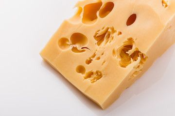Piece and slices of cheese on a white background