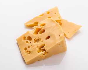 Piece and slices of cheese on a white background