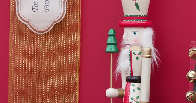 Small Red Nutcracker Standing Among Presents in Christmas / Holiday Display