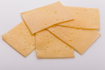 Piece and slices of cheese on a white background