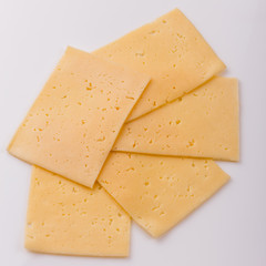 Piece and slices of cheese on a white background