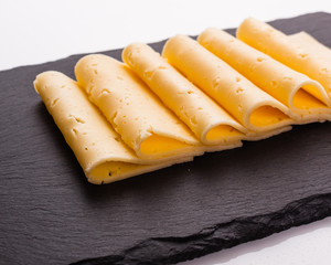 Piece and slices of cheese on a white background