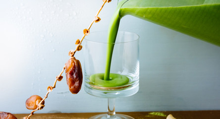 Pouring Dates Spinach Smoothie into a glass