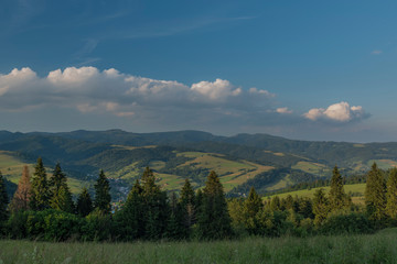 Evening in national park Pieniny with sunny shine over green meadows