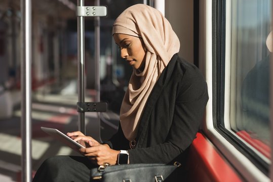 Woman using digital tablet while travelling in train