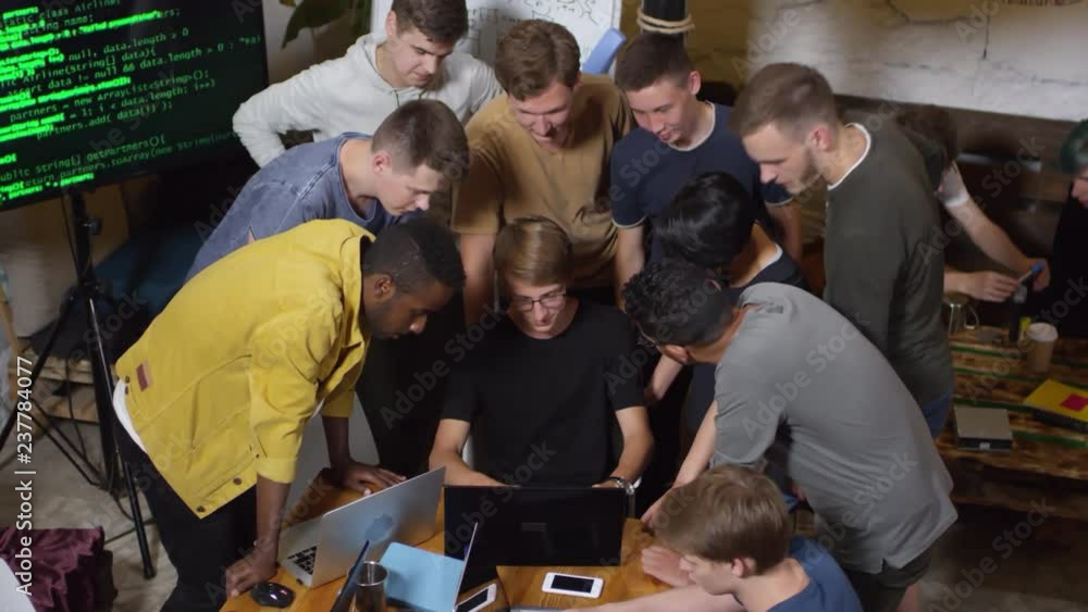 Poster high angle view of group of multiethnic young people leaning on table while one of them sitting and 