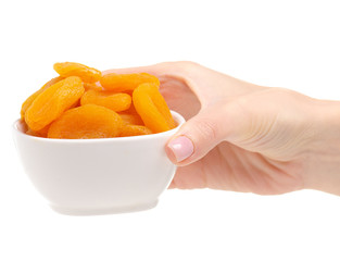 Dried apricots in bowl in hand on white background isolation